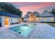 Backyard oasis with a sparkling pool, stylish patio, and guest house, bathed in twilight glow at 422 Palm St, Mount Pleasant, SC 29464