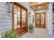 Covered porch showcases double wood doors, brick flooring, and stylish lantern lighting at 422 Palm St, Mount Pleasant, SC 29464