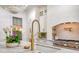 Kitchen sink with a gold faucet, marble countertop, and an ornate chandelier overhead, complemented by fresh flowers at 422 Palm St, Mount Pleasant, SC 29464