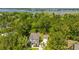 A high aerial view of a gray two-story home, separate garage, lush green trees, lawn, and waterfront in the distance at 474 Woodspring Rd, Mount Pleasant, SC 29466