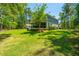Beautifully landscaped backyard with mature trees, well-maintained lawn, and a screened porch at 474 Woodspring Rd, Mount Pleasant, SC 29466