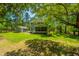 Large backyard with mature trees, lush lawn, and a charming screened porch, perfect for outdoor enjoyment at 474 Woodspring Rd, Mount Pleasant, SC 29466