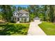Charming two-story home with a well-manicured lawn and separate garage, surrounded by lush green trees, on a sunny day at 474 Woodspring Rd, Mount Pleasant, SC 29466