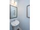 Charming powder room featuring a pedestal sink, framed mirror, and decorative wall art at 474 Woodspring Rd, Mount Pleasant, SC 29466