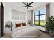 A staged bedroom with a plush bed, neutral decor, and a view of greenery at 5 Gadsdenboro St # 503, Charleston, SC 29401