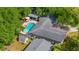 An aerial view shows a backyard pool with an umbrella table and many mature trees around the home at 5 S Basilica Ave, Hanahan, SC 29410