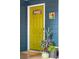 Close-up of a yellow front door with decorative plants and a welcome mat at 5 S Basilica Ave, Hanahan, SC 29410