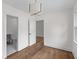 Cozy bedroom with hardwood floors, neutral walls, modern light fixture, and a bathroom doorway at 5163 W Dolphin St, North Charleston, SC 29405