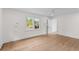 Light-filled bedroom with hardwood floors, white walls, modern lighting, and an open doorway at 5163 W Dolphin St, North Charleston, SC 29405