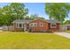 Charming brick home with a well-maintained lawn, beautiful landscaping, and inviting front entrance at 5163 W Dolphin St, North Charleston, SC 29405