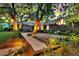Inviting brick home surrounded by lush landscaping and mature trees, with a stone walkway at 521 Pelzer Dr, Mount Pleasant, SC 29464