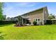 Spacious backyard featuring a screened-in porch and an outdoor seating area on a sunny day at 5451 Kings River Dr, North Charleston, SC 29420
