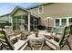Inviting backyard featuring a screened porch, a patio with seating, and a charming fire pit area surrounded by chairs at 5451 Kings River Dr, North Charleston, SC 29420