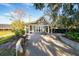 Charming home exterior featuring a screened porch, stone chimney, grill, and concrete driveway at 5451 Kings River Dr, North Charleston, SC 29420
