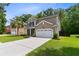 Well-maintained two-story home with a spacious driveway, a two-car garage, and lush green landscaping at 5451 Kings River Dr, North Charleston, SC 29420