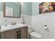 Stylish powder room with a decorative mirror and wainscoting at 5451 Kings River Dr, North Charleston, SC 29420