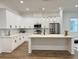 Modern kitchen featuring white cabinetry, stainless steel appliances, and a central island with countertop seating at 5841 Kirkwood Ave, North Charleston, SC 29406