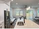 Open living space with a kitchen island, stainless steel refrigerator, dining area, and backyard views at 5841 Kirkwood Ave, North Charleston, SC 29406