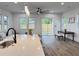 Bright and airy living area with a kitchen island, dining table, and access to outdoor views through sliding glass doors at 5841 Kirkwood Ave, North Charleston, SC 29406