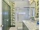 Elegant bathroom with shower over tub, patterned wallpaper, and a mirrored vanity at 6 Intracoastal Ct, Isle of Palms, SC 29451