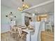 Bright dining room features a white table, stylish lighting, and a view into the kitchen at 6 Intracoastal Ct, Isle of Palms, SC 29451