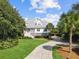 Charming two-story home featuring a well-manicured lawn, a long driveway, and mature trees at 6 Intracoastal Ct, Isle of Palms, SC 29451