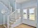 Inviting foyer features a staircase with white railings and a door with views of the golf course at 6 Intracoastal Ct, Isle of Palms, SC 29451