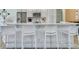 Modern kitchen island with bar stool seating, marble countertops, stainless steel appliances and sleek design at 6 Intracoastal Ct, Isle of Palms, SC 29451