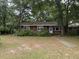 Charming single-story brick home with a welcoming front yard, surrounded by mature trees and established landscaping at 609 Coral St, Mount Pleasant, SC 29464