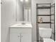 Bathroom features a white sink vanity and a mirror, complimented by a nearby toilet with a shelving unit overhead at 6260 Brandt St # 4-D, North Charleston, SC 29406