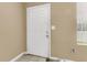 This entryway showcases a white door with neutral-toned walls and tiled floors, with a window providing natural light at 6260 Brandt St # 4-D, North Charleston, SC 29406
