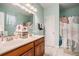 Bright bathroom featuring a double vanity, large mirror, and a shower with stylish curtain at 632 Grassy Hill Rd, Summerville, SC 29483