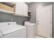 Bright laundry room equipped with a washer, dryer, overhead storage and convenient access to the exterior at 632 Grassy Hill Rd, Summerville, SC 29483