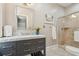 Bathroom featuring a gray vanity, marble countertops, tiled shower and a framed mirror at 8 Prioleau St # Th A, Charleston, SC 29401