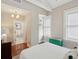 Sunlit bedroom featuring white trim, hardwood floors, and glimpses into the ensuite bathroom at 8 Prioleau St # Th A, Charleston, SC 29401