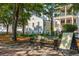 Street view of a multi-story building with architectural detail, park bench and sign at 8 Prioleau St # Th A, Charleston, SC 29401