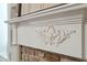 Close up of a decorative white mantle over an exposed brick fireplace with detailed carvings at 8 Prioleau St # Th A, Charleston, SC 29401