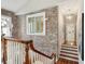 Hallway with exposed brick and a wooden staircase leading to a brightly lit landing at 8 Prioleau St # Th A, Charleston, SC 29401