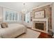 Main bedroom features a crystal chandelier, fireplace with exposed brick and a plush bed at 8 Prioleau St # Th A, Charleston, SC 29401