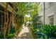 Charming brick walkway lined with lush greenery and trees, leading to a serene garden area at 8 Prioleau St # Th A, Charleston, SC 29401