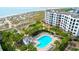 Aerial view of a beachfront condo complex featuring a pool, lounge chairs, and beach access at 8000 Palmetto Dr # 104-A, Isle of Palms, SC 29451