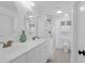 All-white bathroom with a glass shower, a double vanity, and neutral paint at 8000 Palmetto Dr # 104-A, Isle of Palms, SC 29451