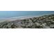 Aerial view of the beach showcasing the shoreline, ocean waves, and sandy dunes at 8000 Palmetto Dr # 104-A, Isle of Palms, SC 29451