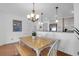 Bright dining area featuring a wooden table, chandelier lighting, and a view into the kitchen at 8000 Palmetto Dr # 104-A, Isle of Palms, SC 29451