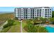 Exterior view of the condo building featuring multiple balconies, beach access, and tropical landscaping at 8000 Palmetto Dr # 104-A, Isle of Palms, SC 29451