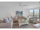 Bright living room with comfortable seating, a ceiling fan, and natural light from the windows at 8000 Palmetto Dr # 104-A, Isle of Palms, SC 29451