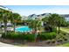 Community pool surrounded by palm trees and nearby homes with a beautiful garden at 8000 Palmetto Dr # 104-A, Isle of Palms, SC 29451