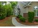 View of the side of the property showcasing manicured shrubbery, brick accents and a walkway leading to the entrance at 8624 Grassy Oak Trl, North Charleston, SC 29420