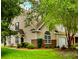 Charming two-story home with tan siding, brick accents, manicured lawn and mature landscaping provides great curb appeal at 8624 Grassy Oak Trl, North Charleston, SC 29420
