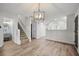 Open-concept living room with staircase and modern light fixture, with Luxury Vinyl Plank flooring at 8624 Grassy Oak Trl, North Charleston, SC 29420